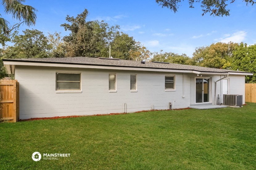 the exterior of a white house with a yard and grass