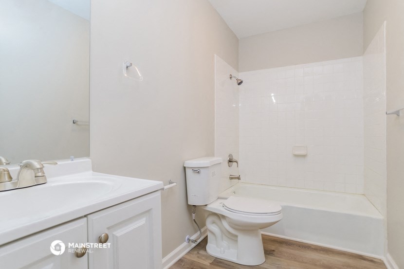 a bathroom with a toilet and a tub and a sink