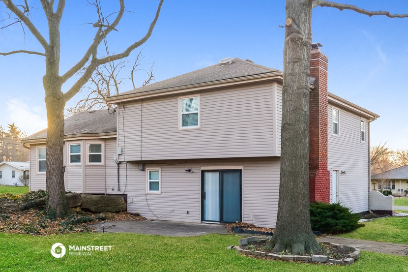 a white house with two trees in front of it