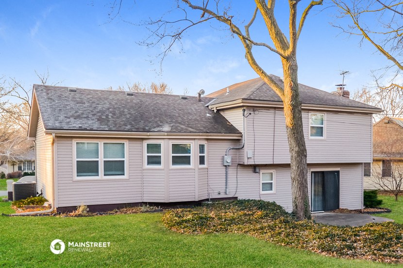 a gray house with a tree in front of it