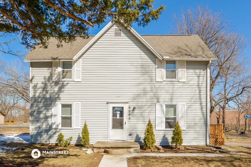 a white house with a tree in front of it