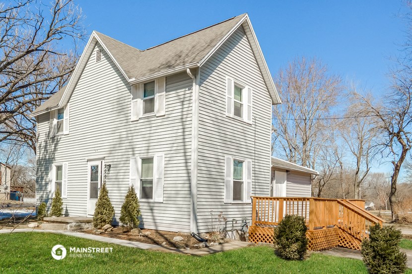 a white house with a wooden deck in front of it