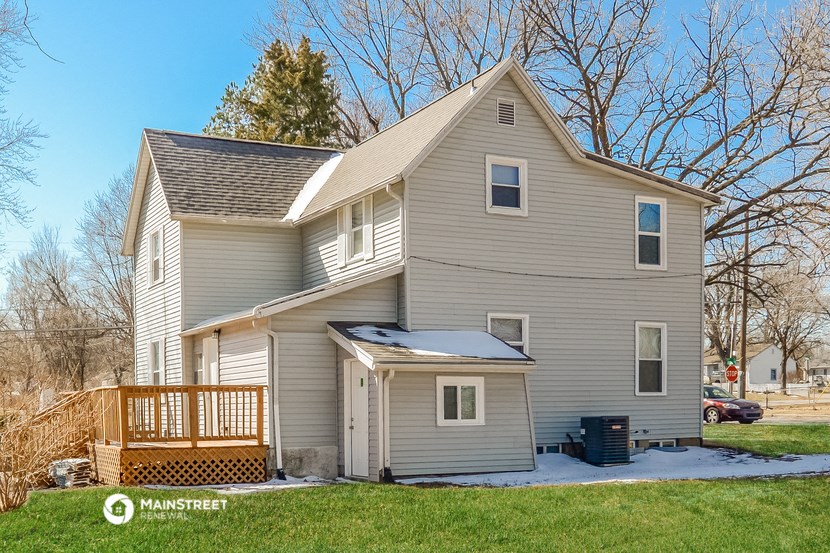 a white house with a deck on the side of it