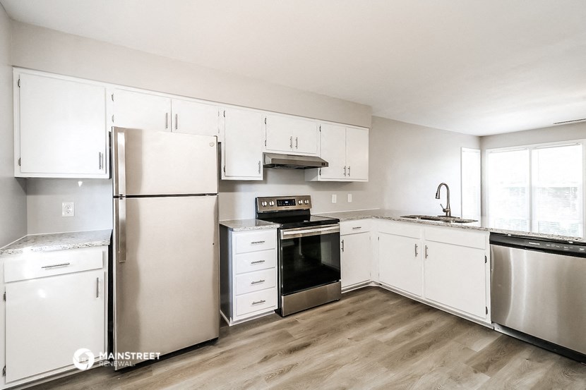 a white kitchen with stainless steel appliances and white cabinets