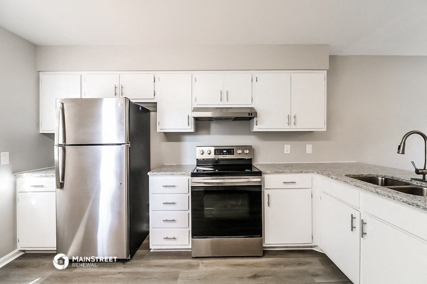 a kitchen with white cabinets and stainless steel appliances