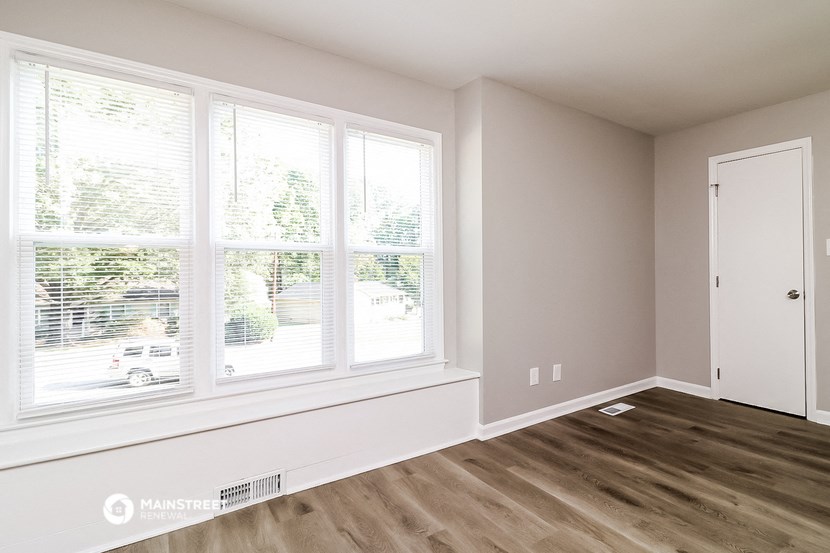 a living room with a large window and wood floors