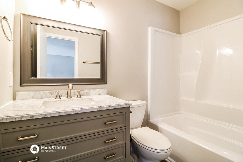 a bathroom with a sink toilet and a mirror