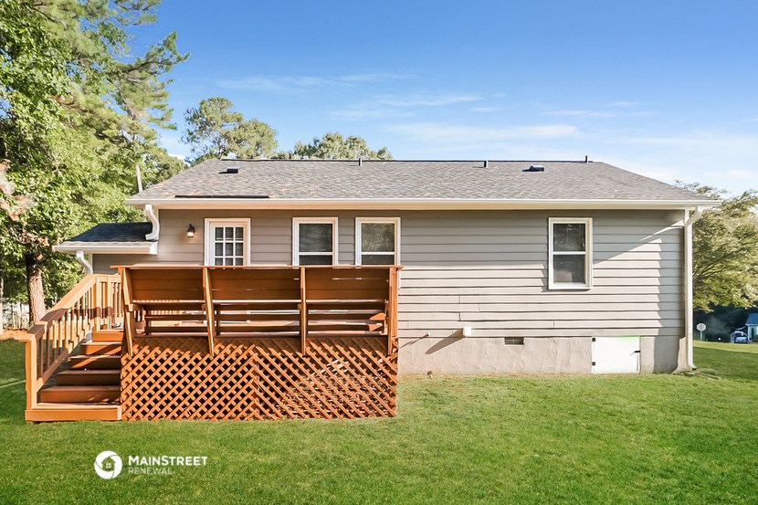 a backyard with a deck and a house
