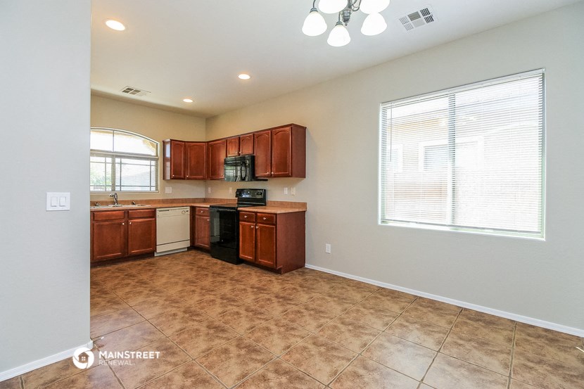 an empty kitchen with wooden cabinets and a window