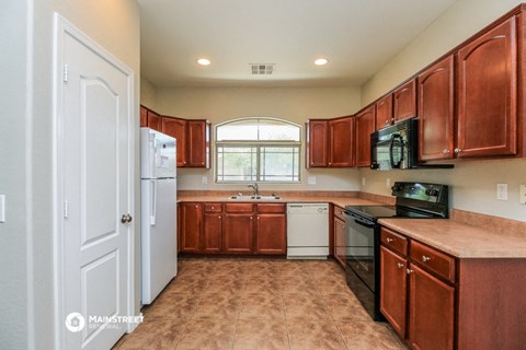 a kitchen with wooden cabinets and a white refrigerator