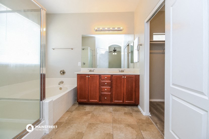 a bathroom with a tub and a sink and a mirror