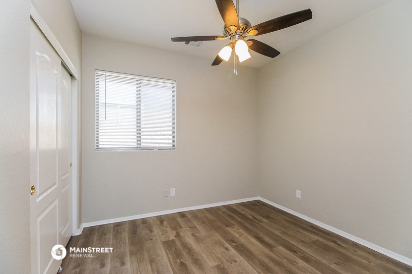 an empty room with a ceiling fan and a door