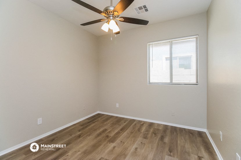 an empty room with a ceiling fan and a window