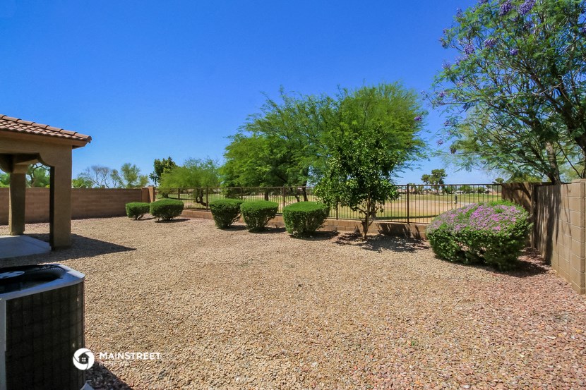 the backyard of a home with a fence and trees
