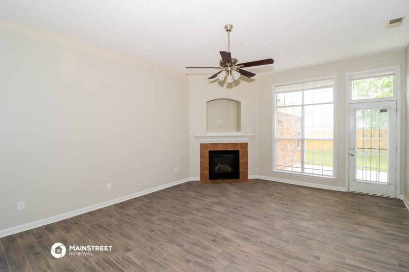 the living room with fireplace and ceiling fan