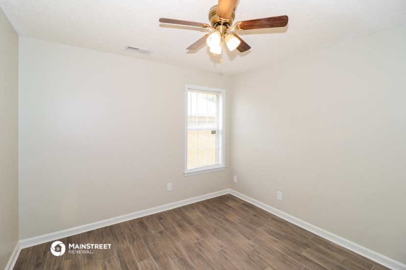 a living room with a ceiling fan and a window