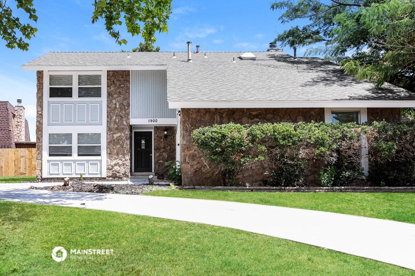 a house with a lawn and a sidewalk in front of it