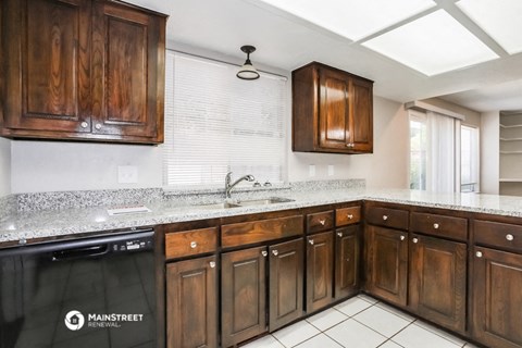 a kitchen with wooden cabinets and granite counter tops