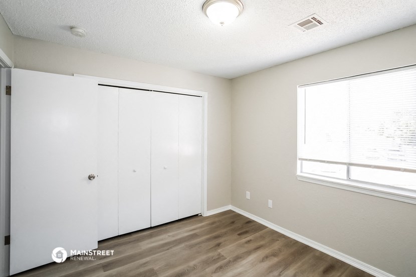an empty room with a closet and a window