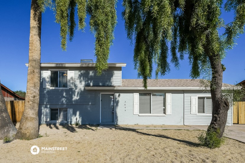 a blue house with a tree in front of it