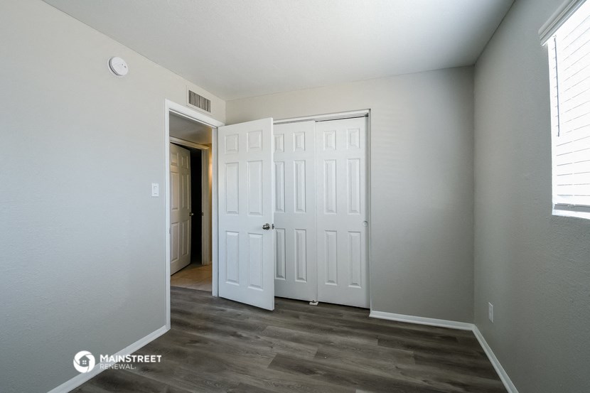 a bedroom with two closets and a door to a hallway
