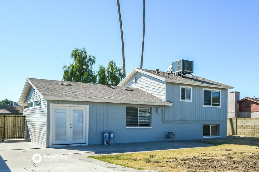 a white house with a gray roof and a blue sky