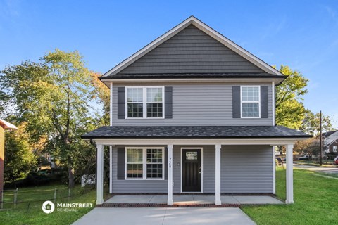 the front of a house with a sidewalk in front of it