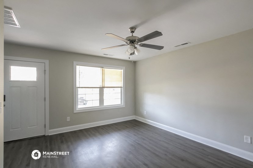 an empty room with a ceiling fan and a window