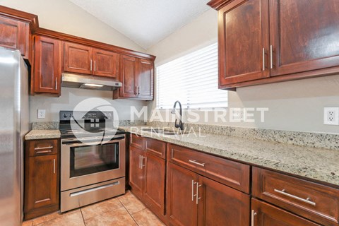 a kitchen with wooden cabinets and granite counter tops