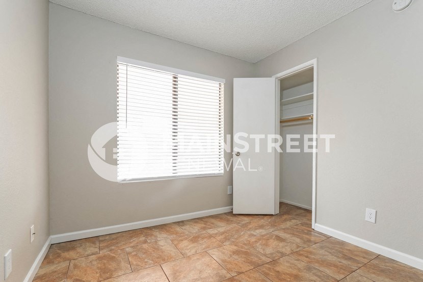 a bedroom with a large window and a closet