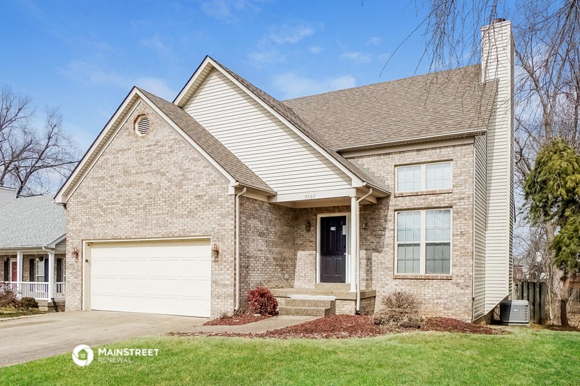 a tan brick house with a white garage door