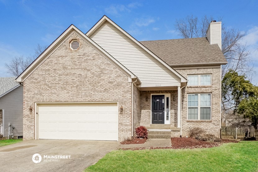 a tan brick house with a white garage door