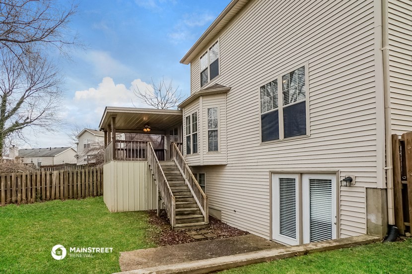 the back of a house with a deck and a wooden fence