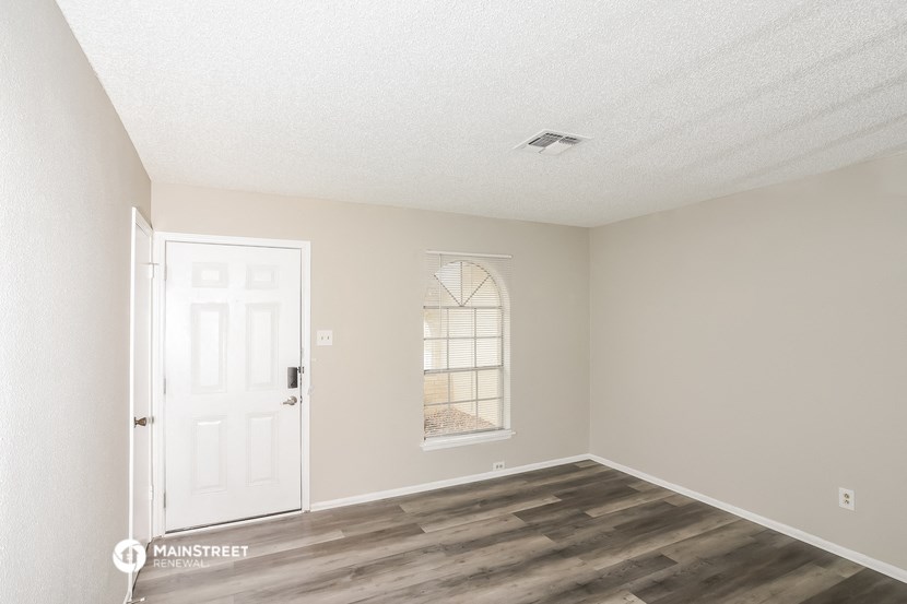 an empty room with a white door and a window