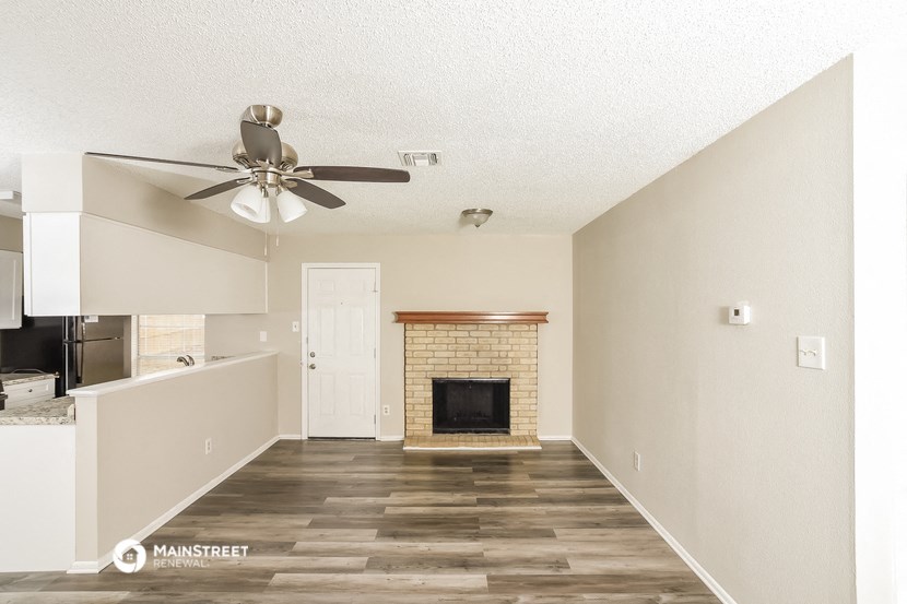 a living room with a fireplace and a ceiling fan