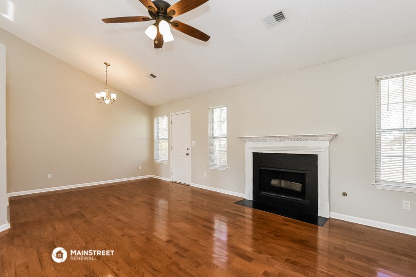 a living room with a fireplace and a ceiling fan