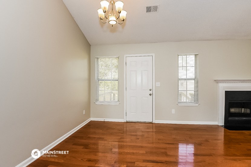 the living room of a house with a fireplace and a white door