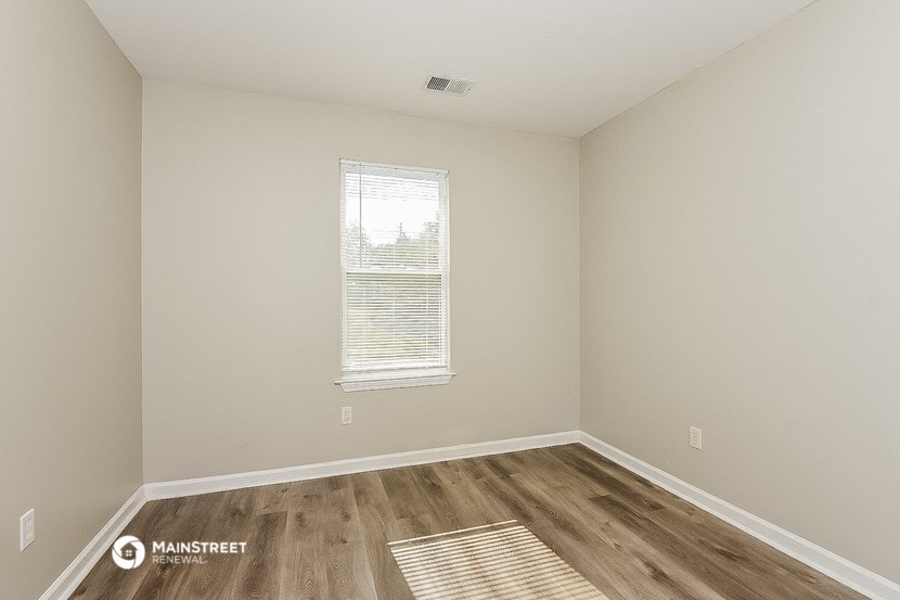 an empty room with wood floors and a window