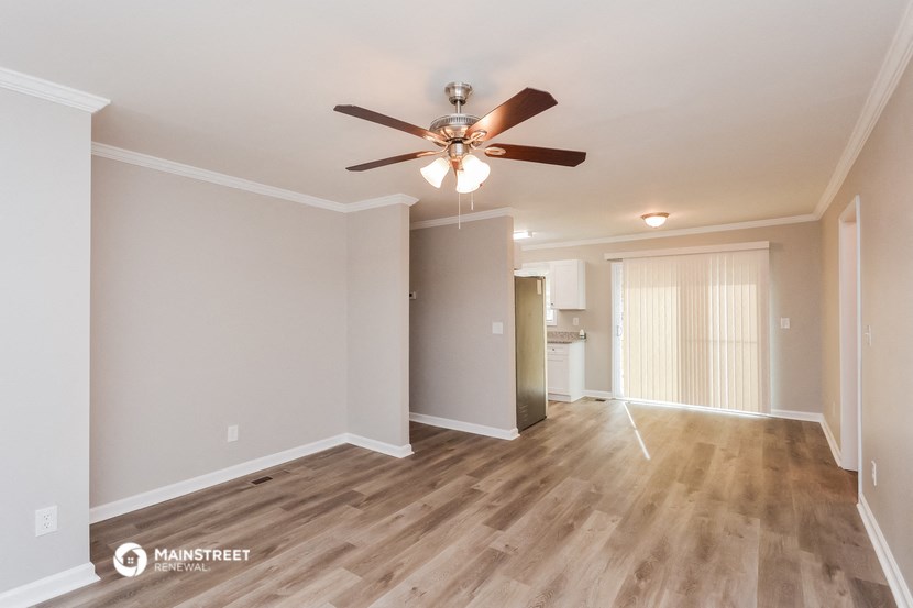 the spacious living room with ceiling fan and hardwood flooring
