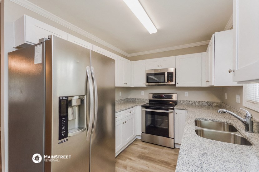 a kitchen with stainless steel appliances and white cabinets