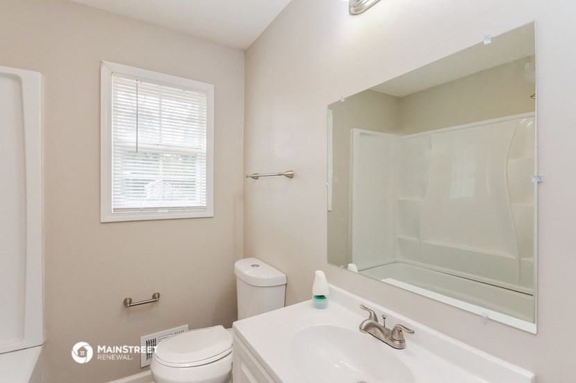 a bathroom with a large mirror and a sink and a toilet