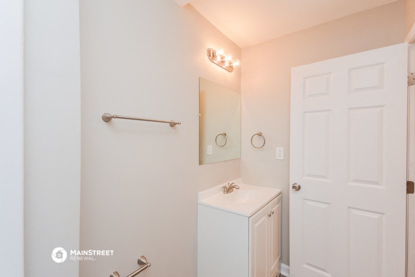 a bathroom with a sink and a mirror and a white door