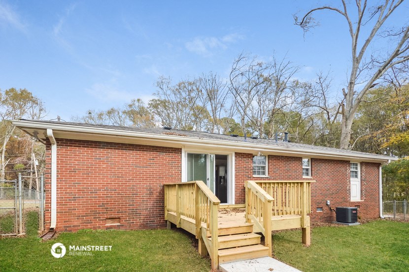 a small brick house with a porch and a deck