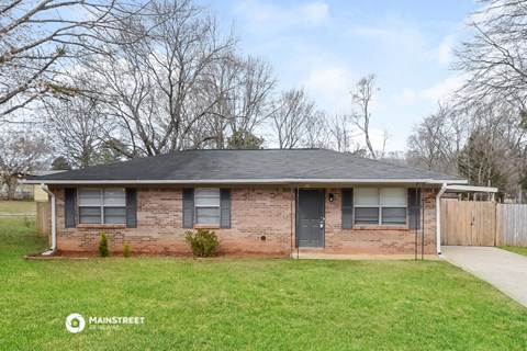 a brick house with a yard and a sidewalk