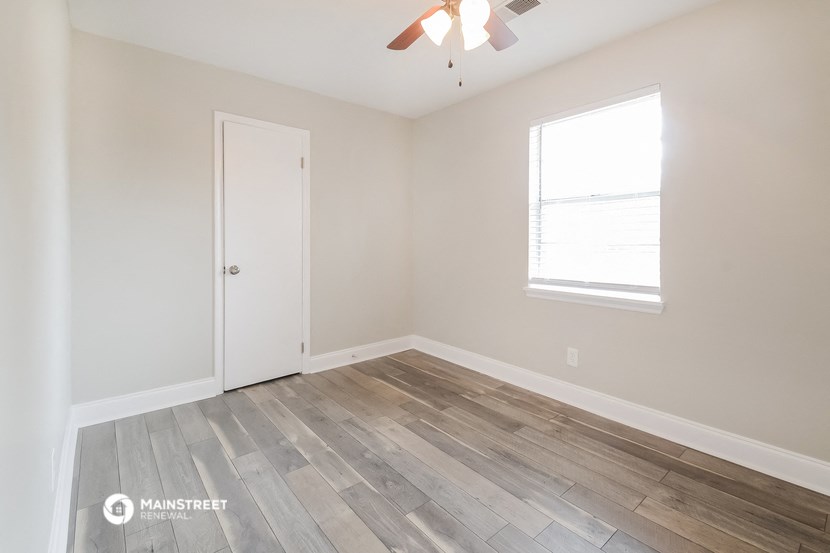 the bedroom with hardwood flooring and a ceiling fan