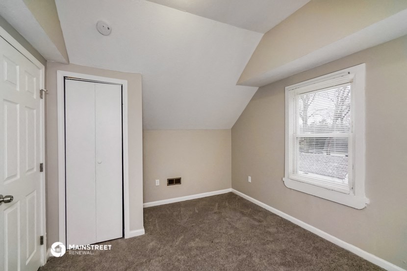 the upstairs bedroom with carpet and a door to the closet