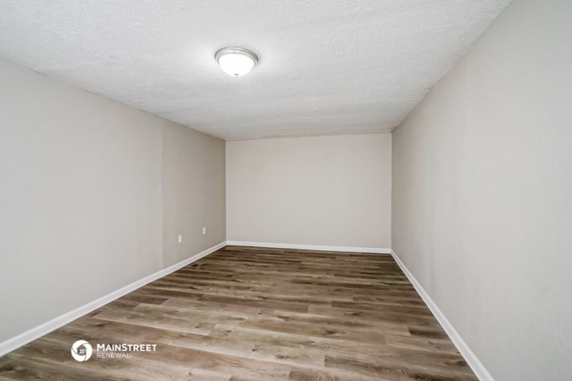 a empty room with wood flooring and white walls