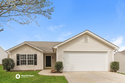 a beige house with a driveway and a garage door
