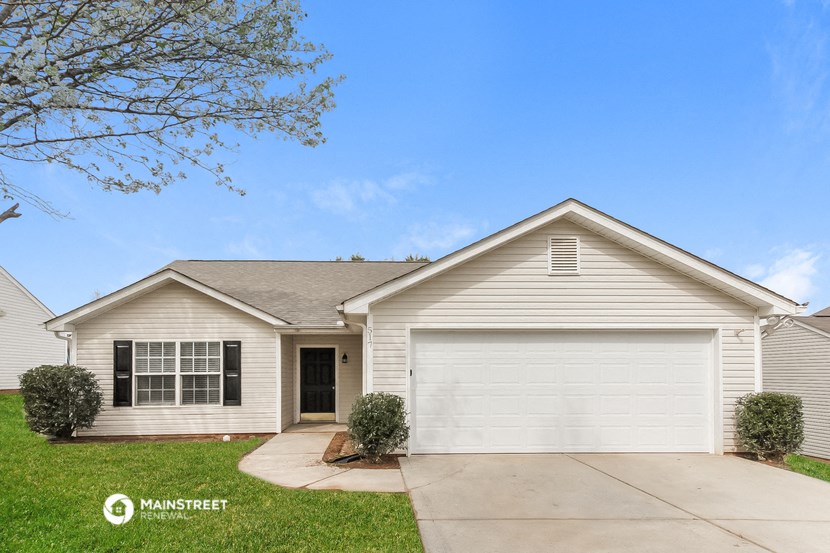 a white house with a driveway and a garage door
