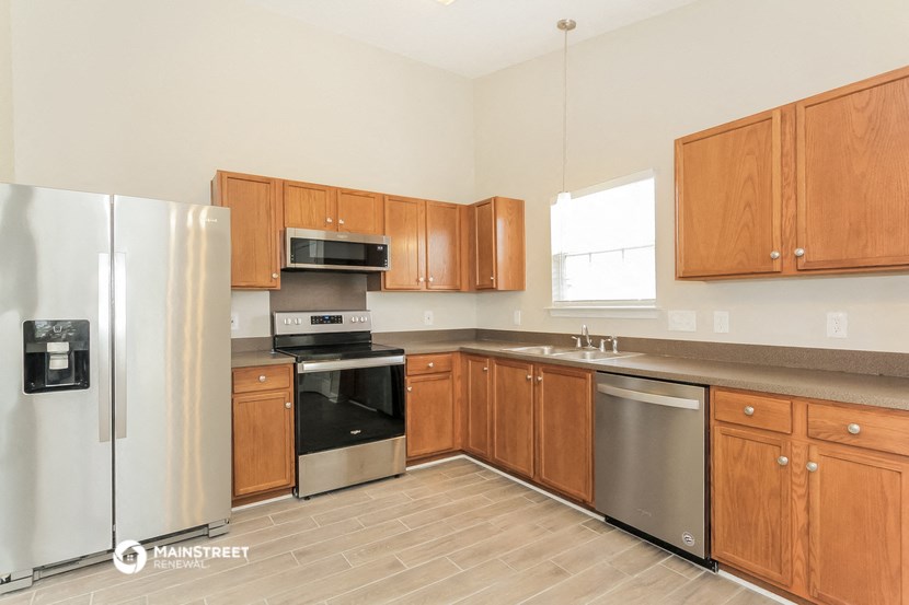 a kitchen with wooden cabinets and stainless steel appliances